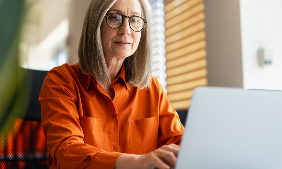 Woman sitting at desk using a laptop.