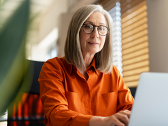 Woman sitting at desk using a laptop.