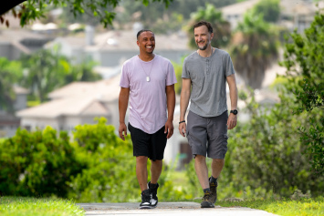 Two people walk along a path.