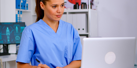 Doctor assistant in uniform working on laptop.