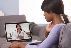 Woman on a video call with a doctor on her laptop.