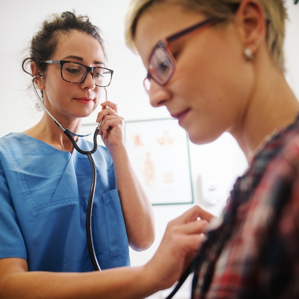 Doctor checking a patient's heart with a stethescope