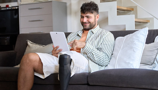 Man with prosthetic using tablet