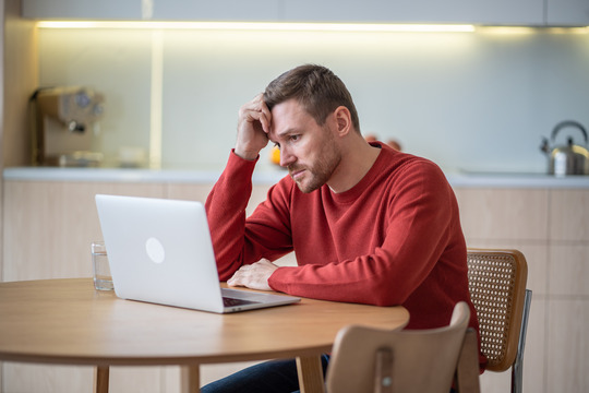 Frustrated man using laptop