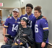 three professional football players and veteran in wheelchair 