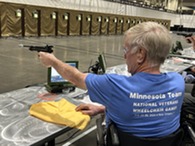 person in wheelchair shooting with a fake gun