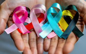 Hand holding different colored awareness ribbons.