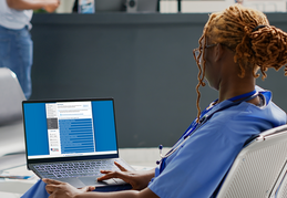 Nurse browsing CDI list on laptop.