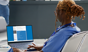Nurse browsing CDI list on laptop.