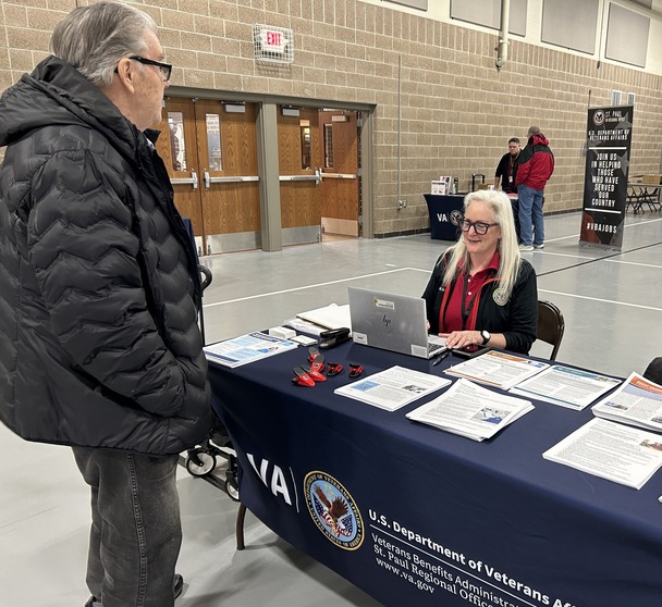 person sitting at table talking to veteran
