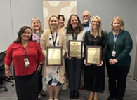 group smiling with graduation certificates 