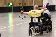 person in wheelchair with bow and arrow