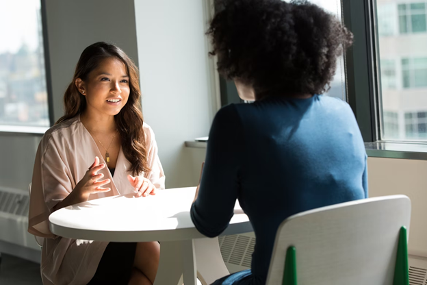 Two women sitting at table and talking