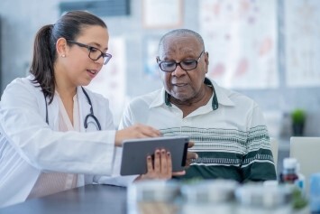 A person at a medical facility speaks with a medical professional. 