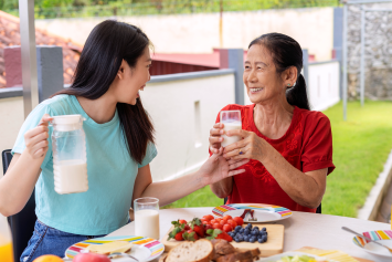 Two people talk over breakfast.