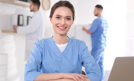 Nurse sitting at desk with a laptop.