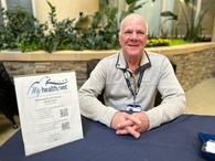 man sitting at desk smiling
