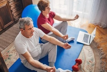 Two people sit and meditate together.