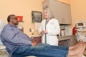 A person sits and speaks with their doctor.