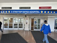 person walking into building with 5 star sign above doors