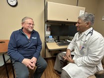 person in lab coat smiling with patient