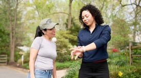 Two women looking at watch 