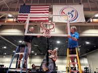 people hanging a basketball hoop