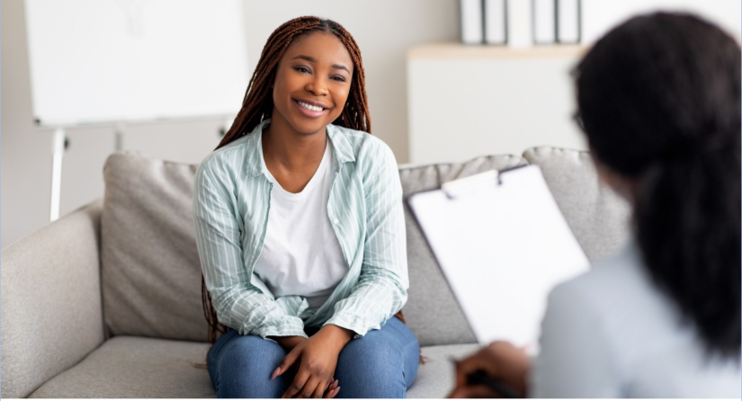 Health professional taking notes while listening to woman during support session