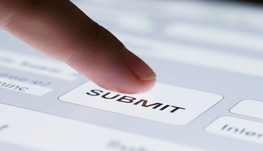Finger clicking submit button on a form on a tablet.