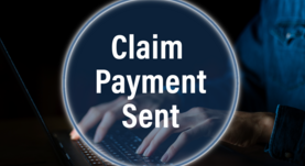 Hands typing on a laptop with a claim payment sent button on top.