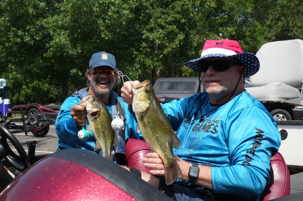 two people in a fishing boat holding up fish