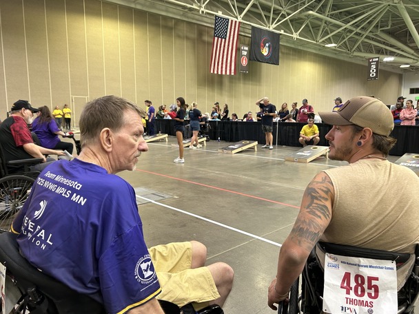 two people sitting in wheelchair talking