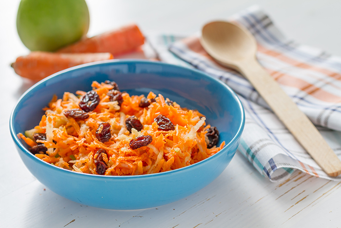 A prepared apple carrot salad in a blue bowl. 
