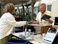two people exchanging computer and laptops for recycling