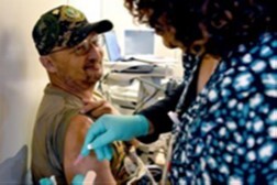 Staff member administering a flu vaccine to patient