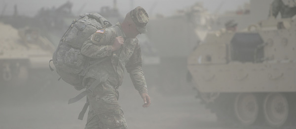 Soldier walking in sand storm.