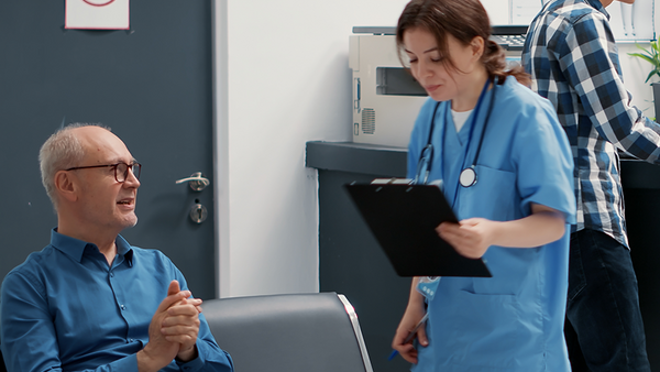 Busy reception desk with many patients waiting.