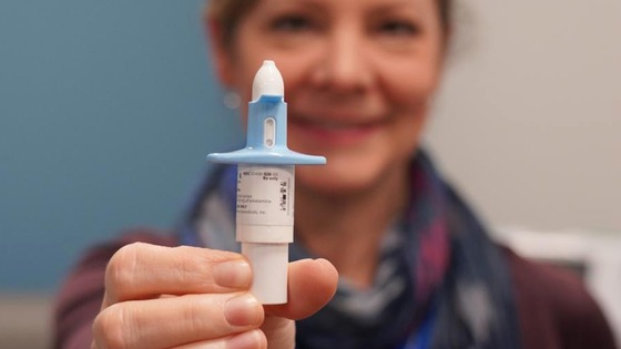 Hand holding a small tube of lotion or ointment