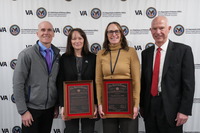 a group with two people holding awards