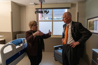 two people standing in a patient room