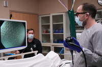 medical room with doctor wearing a mask and performing a procedure 