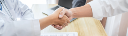 Two people shaking hands as they introduce themselves