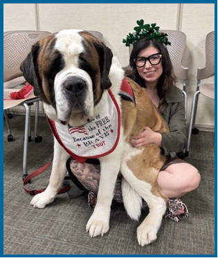 Change Management Agent, Katie Howard sits with a huge St. Bernard on her lap.