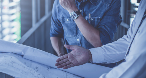 Two people reviewing blueprints. 