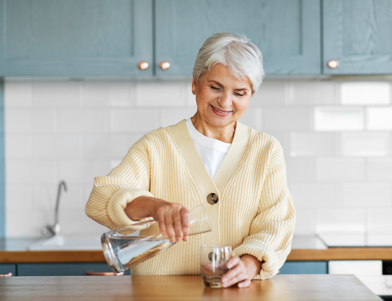 Older woman pouring a glass of water 