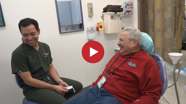 Video thumbnail showing an older Veteran smiling and laughing with a male dentist at a dental appointment