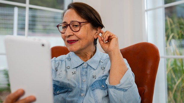 woman adjusting hearing aid