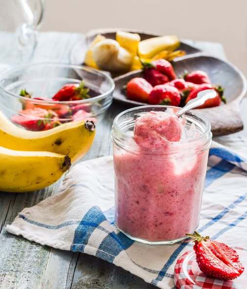Bananas, strawberries and a fresh berry‑lime banana sorbet in a glass.