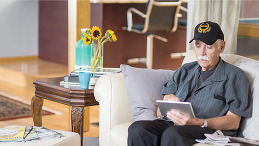 Veteran on the couch, using a tablet.