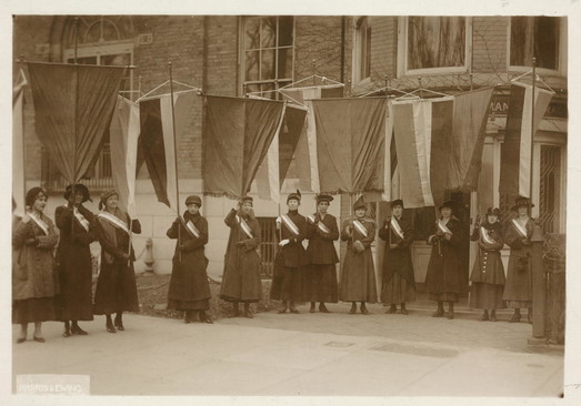 Photograph of picket line of National Woman's Party members holding banners in front of NWP headquarters.
